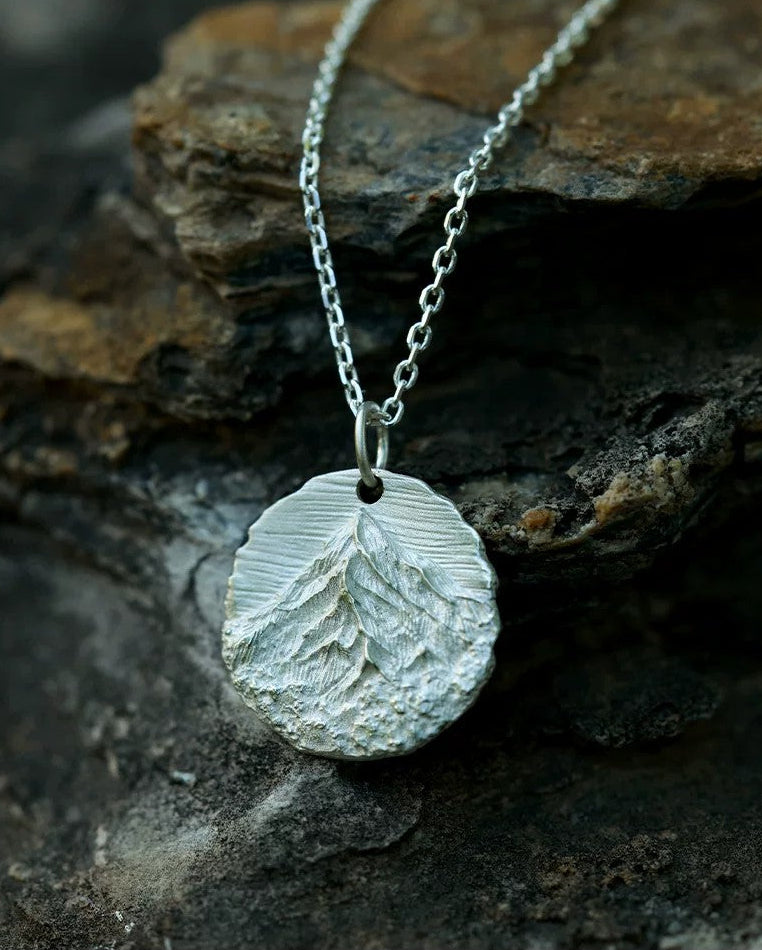 Kailash Peak Relic Pendant — styling angle on stone with silver chain